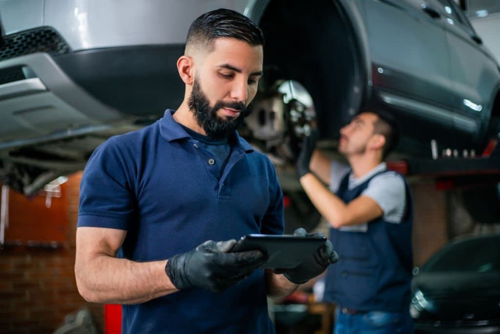 A mechanic working on a car engine, representing vehicle service and inspection.